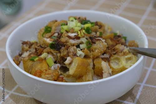Bubur ayam / chicken porridge is Indonesian rice porridge with shredded chicken and chunks of cakwe.