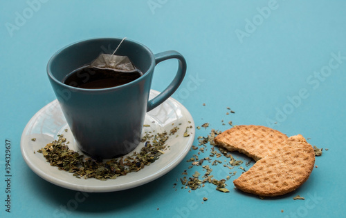 Simple afternoon snack. Cup of tea and biscuits on a light blue background. 
