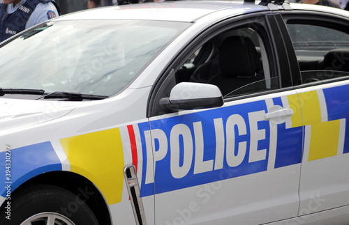 Close up New Zealand police car with policeman on background