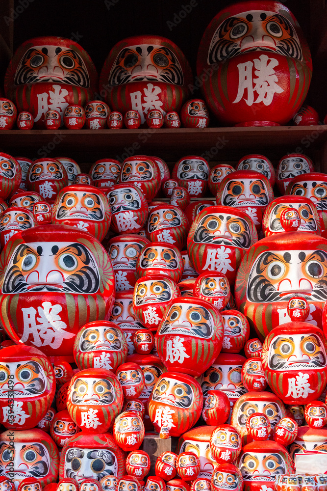 Daruma, round traditional Japanese dolls decorated in the garden of Katsuou-ji temple in Minoh, Osaka, Japan.  Notes: Japanese character on daruma means 
