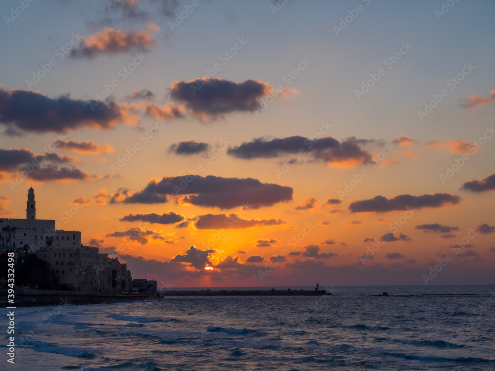 Coastal view of the ancient city of Yafo or Jaffanear Tel Aviv, Israel. Cityscape in sunset hour with clouds in the sky.