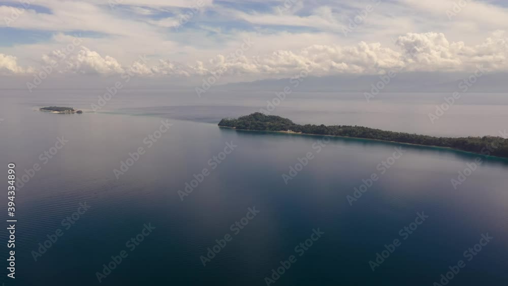 Top view of small tropical Big Liguid Island in the blue sea with a coral reef and the beach. Big Cruz Island, Philippines, Samal. Top view of small tropical Big Liguid Island in the blue sea with a coral reef and the beach. Big Cruz Island, Philippines, Samal.