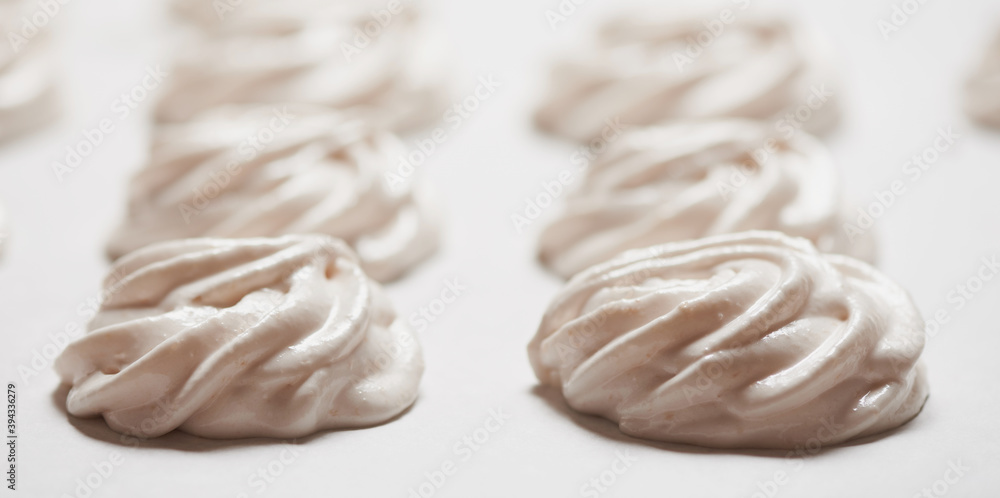 Cooked homemade meringue cookies on baking paper Cooked homemade meringue cookies on baking paper