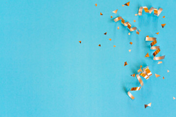 close up on group of gold color of rolling ribbon and confetti on teal background with copy space for christmas festival happy new year ,carnival , birthday and anniversary, concept design