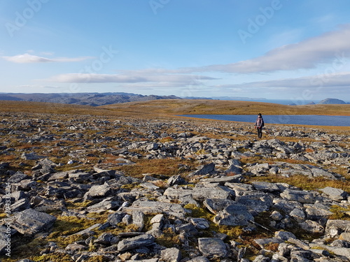 person hiking on barren mountain on the magerøya island, northcape county in autumn