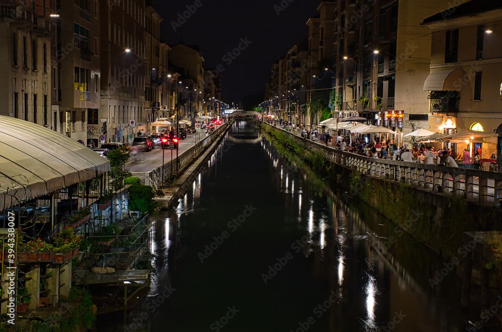 Colorful, stunning, scenic view of Naviglio Paves canal full with restaurants, bars and people in Milan. Long exposure photography