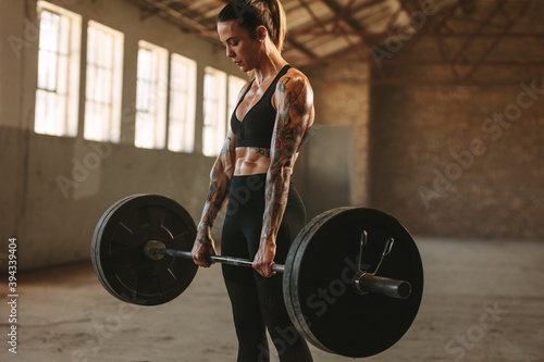 Strong woman exercising with heavy weights photo