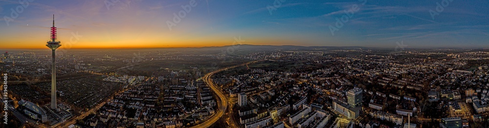 Panoramic drone image of the Frankfurt television tower and Taunus mountains in the evening during a colorful and impressive sunset in winter