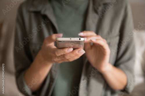 Crop close up of woman text message on modern cellphone gadget at home. Female client customer look at screen browse surf wireless internet connection on smartphone device. Technology concept. © fizkes