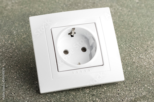white electrical outlet on a dark background. plastic socket with decorative frame. Close-up