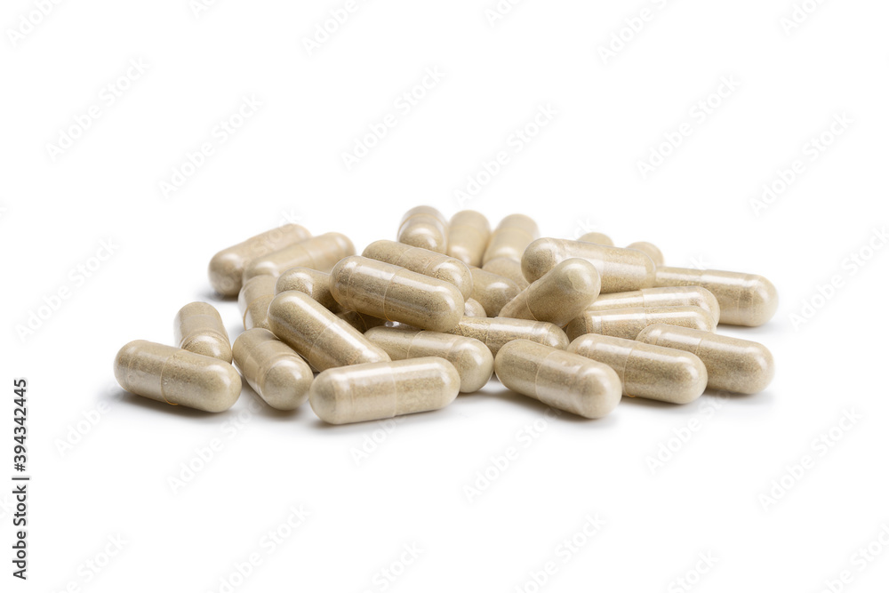 Close-up of a pile of beige colored pills or capsules on isolated white background. Selective Focus. Close-up of a pile of beige colored pills or capsules on isolated white background. Selective Focus.
