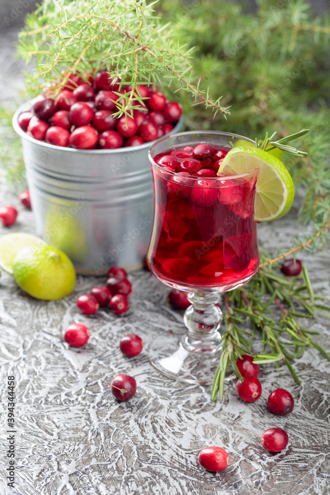 Glass of cranberry drink with berries, lime, and rosemary. Glass of cranberry drink with berries, lime, and rosemary.