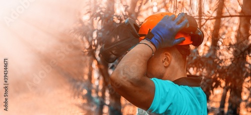 lumberjack with protective helmet in the forest photo