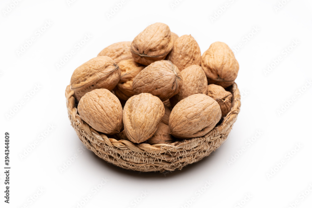 Walnuts in basket on white background Walnuts in basket on white background