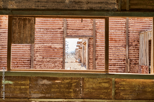 collapsed building with corrugated tin walls of an old saltpeter mining town in the Atacama desert of Chile, South America photo