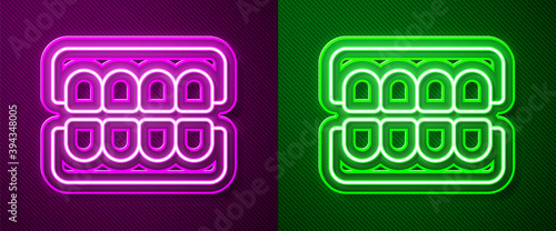 Glowing neon line False jaw icon isolated on purple and green background. Dental jaw or dentures, false teeth with incisors. Vector.