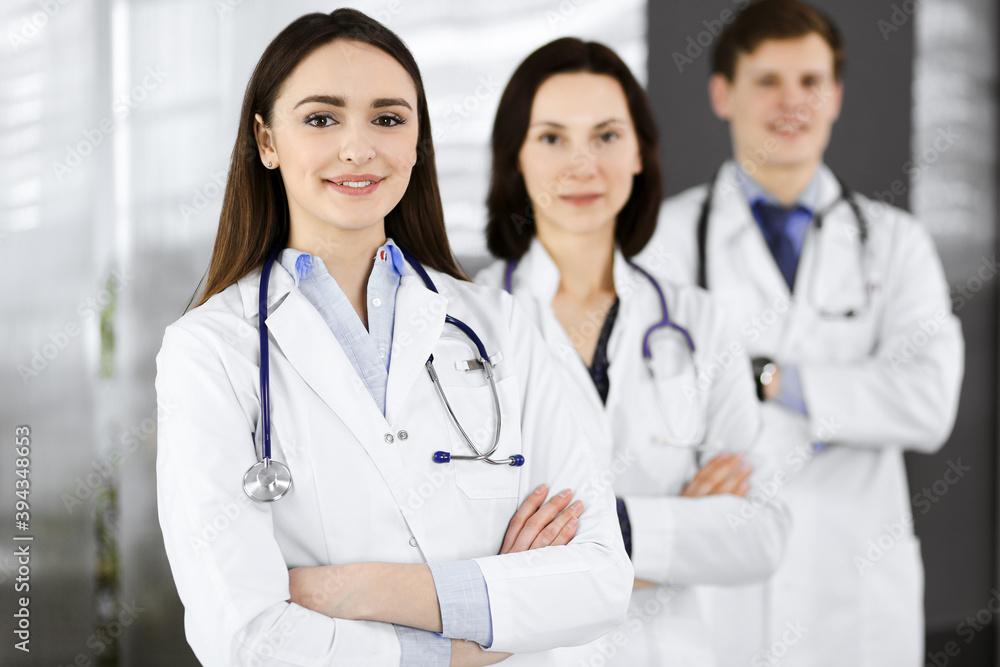 Group of young professional doctors is standing as a team with arms crossed in a hospital office and is ready to help patients. Medical help, insurance in health care, best disease treatment and Group of young professional doctors is standing as a team with arms crossed in a hospital office and is ready to help patients. Medical help, insurance in health care, best disease treatment and