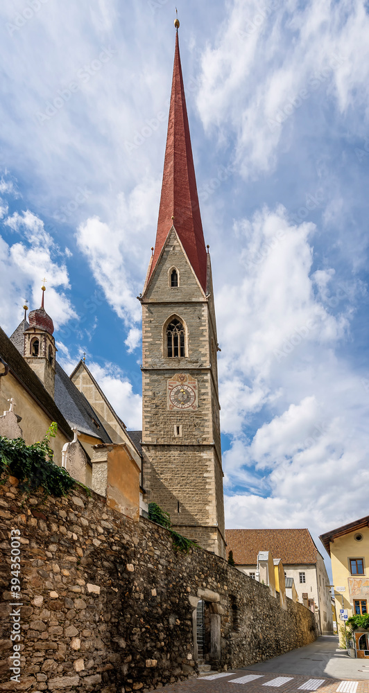 The high bell tower of the parish church of Santa Maria Assunta (in German Pfarrkirche Mariä Himmelfahrt) in Silandro, South Tyrol, Italy, under a beautiful sky