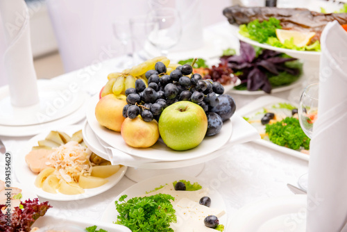  apples, grapes on a plate, served Banquet table,