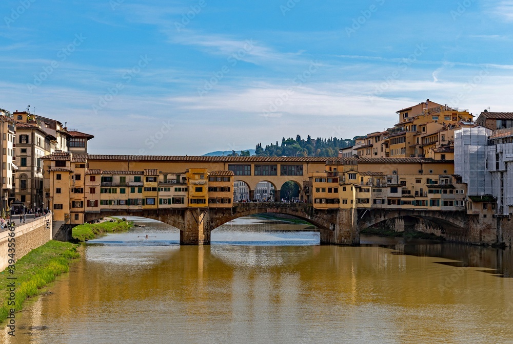 The Ponte Vecchio reflecting on the water of the Arno River at the old town of Florence, Tuscany Region in Italy 