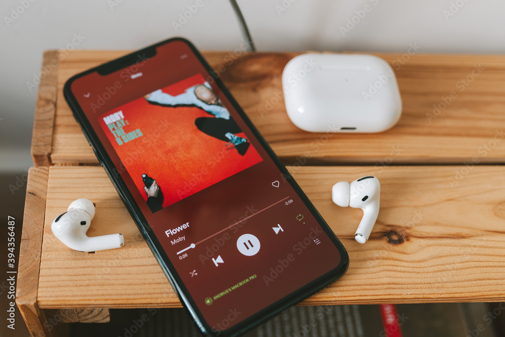Spotify app on the screen and Apple Airpods Pro Photos | Adobe Stock