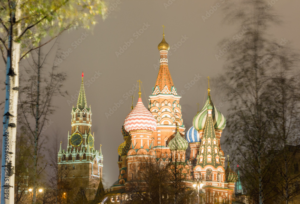 Moscow, Russia, Kremlin. St. Basil's catherdral and Spasskaya tower in night. View from Zaryadye park. Trees swaying in the wind