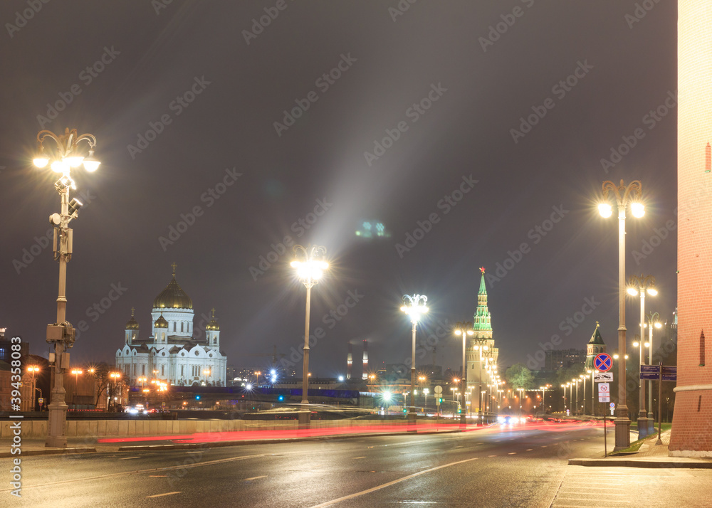 Moscow, Russia. The Kremlin - wall, towers. Kremlevskaya embankment in night. Cathedral of Christ the Saviour in background