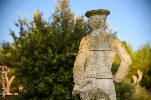 Half bust of an old statue in a garden. Vintage object with sunset light. © Roza_Sean