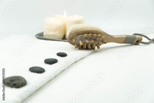 Gray zen pebble hot stones with towel and wooden massager on massage table in beauty salon. Hot stone massage setting. Concept set of harmony  balance and meditation  spa  relax  spa treatment