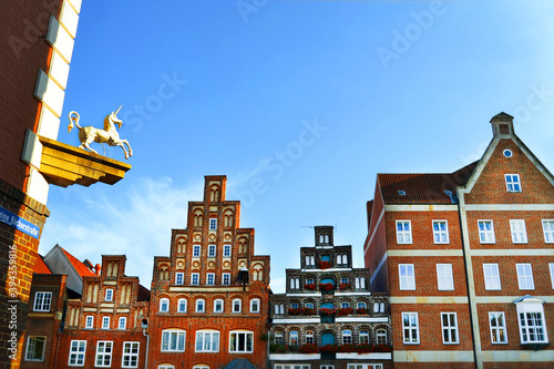 Sunny day in Luneburg, Germany, Europe. Brick gothic architecture and unicorn figurine on a building on Kleine bäckerstraße (small bakerstreet).