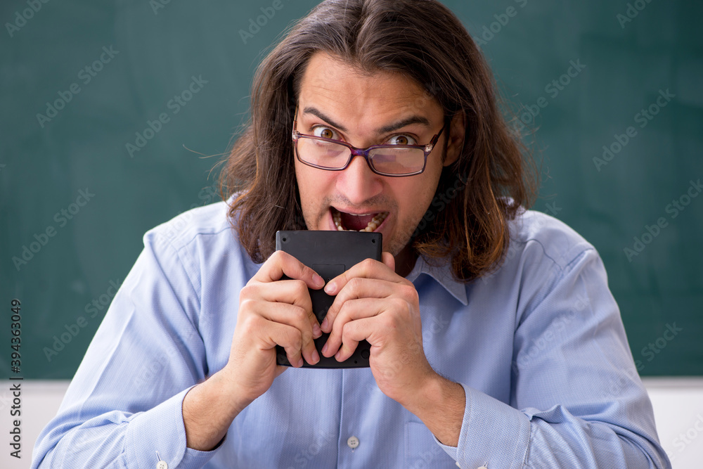 Young male teacher in front of green board Young male teacher in front of green board
