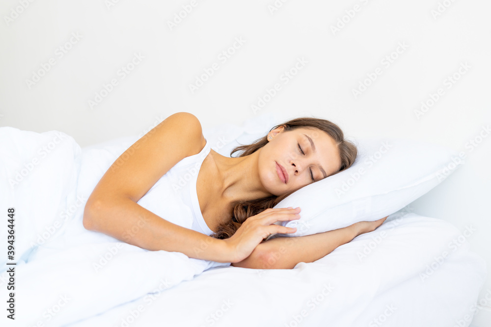 Side view waist portrait of beautiful sleeping woman in bed. Female with long hair resting, good night sleep concept, enjoying fresh soft bedding linen and mattress in bedroom Side view waist portrait of beautiful sleeping woman in bed. Female with long hair resting, good night sleep concept, enjoying fresh soft bedding linen and mattress in bedroom