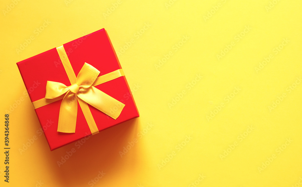 bright red gift box on yellow background bright red gift box on yellow background