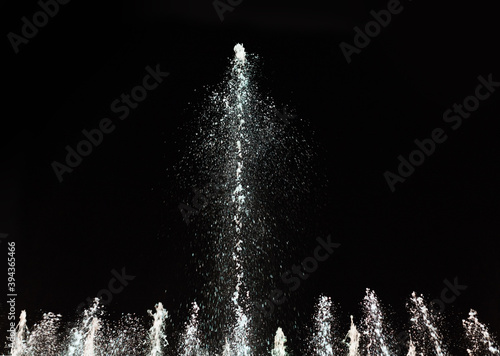 Water fountain on a dark background. Jet and spray in motion.
