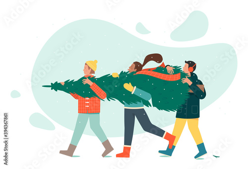 Three people in winter clothes are carrying a Christmas tree.