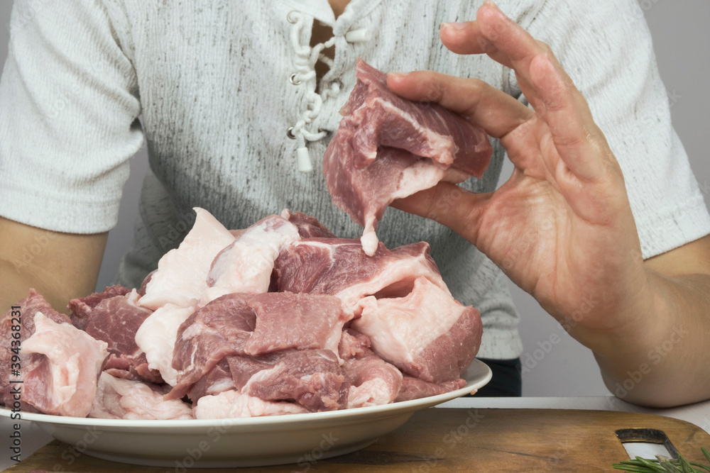 close up women's hands cut delicious, raw, fresh meat with a knife. cooking pork. cooking meat pork steaks