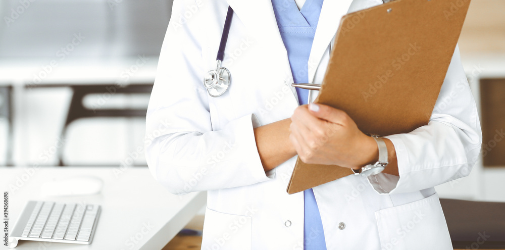 Unknown woman-doctor at work in clinic. Female physician controls medication history record and medical exam results, close-up. Medicine concept Unknown woman-doctor at work in clinic. Female physician controls medication history record and medical exam results, close-up. Medicine concept