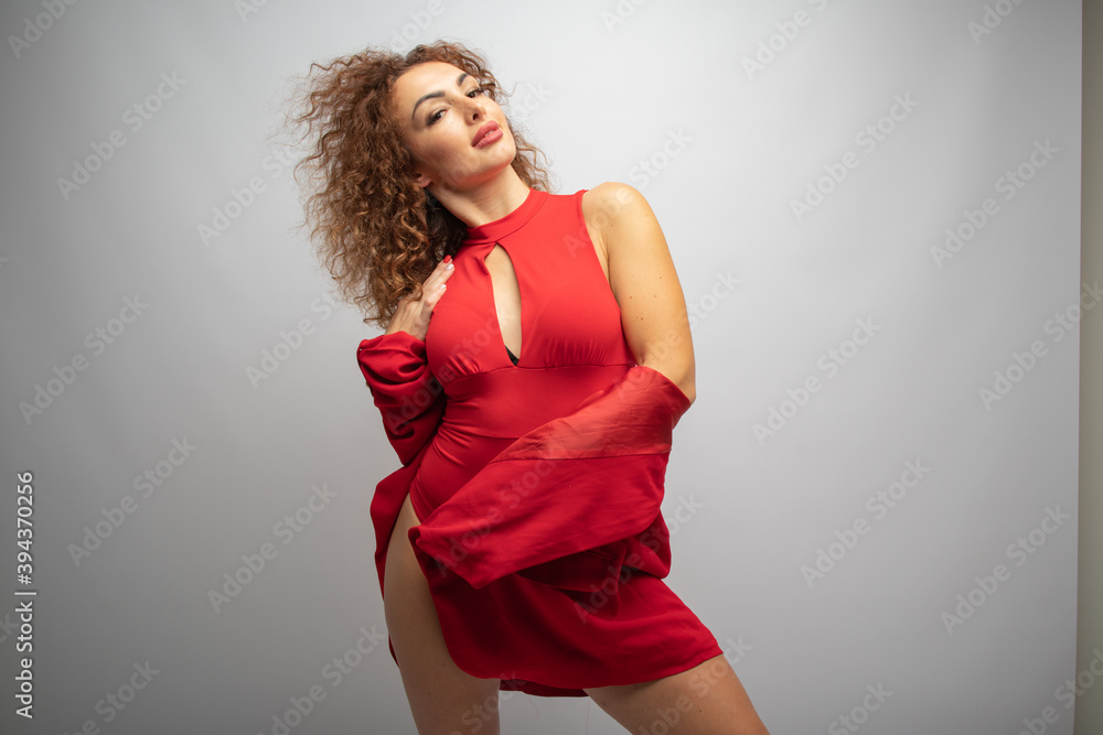 curly girl in red clothes on a white background in a photo studio curly girl in red clothes on a white background in a photo studio