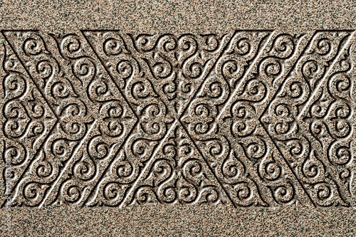 Ornamental print on the stone surface. Vintage ornament on the stone. Close-up seamless texture. Stone texture. Pattern on the stone. Embossed pattern. Wallpaper.