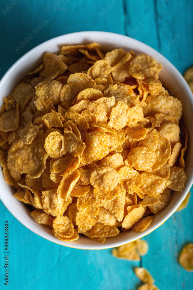 Obraz premium Bowl with tasty corn flakes on wooden table. Top view.
