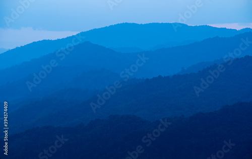 Sun-set moment, the scenery of mountains in layers, dark violet purple, and blue silhouette panoramic view © chongsiri