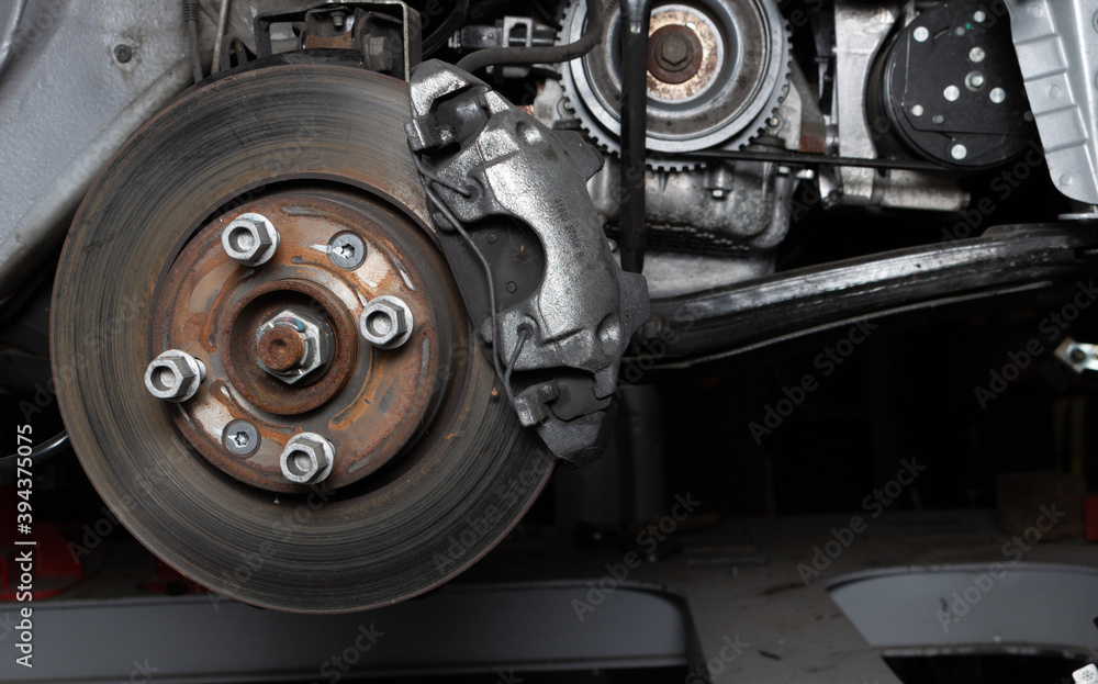 Detail of a car brake in a garage, repairing brake pads Detail of a car brake in a garage, repairing brake pads