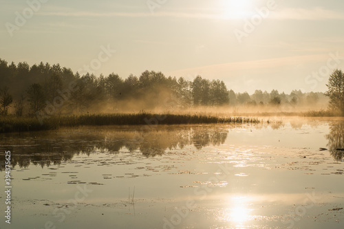 Magic orange sunny and foggy sunrise time. Peaceful calm river landscape. © Andrii Oleksiienko