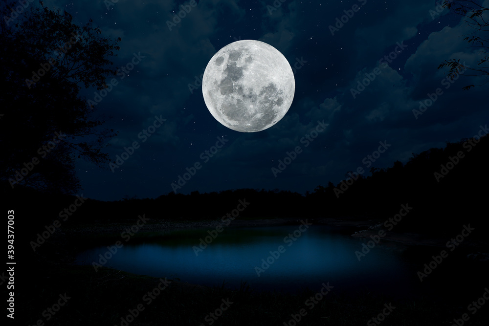 Naklejka premium Full moon over lake at night.