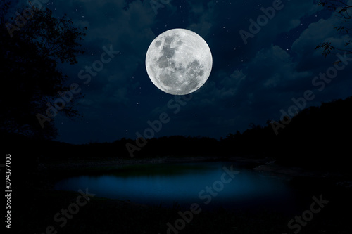 Full moon over lake at night.