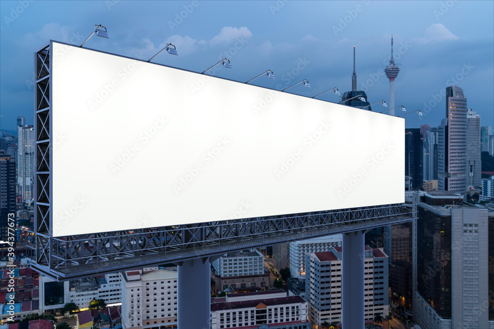 Blank white road billboard with KL cityscape background at night time. Street advertising poster, mock up, 3D rendering. Side view. The concept of marketing communication to promote or sell idea. Blank white road billboard with KL cityscape background at night time. Street advertising poster, mock up, 3D rendering. Side view. The concept of marketing communication to promote or sell idea.