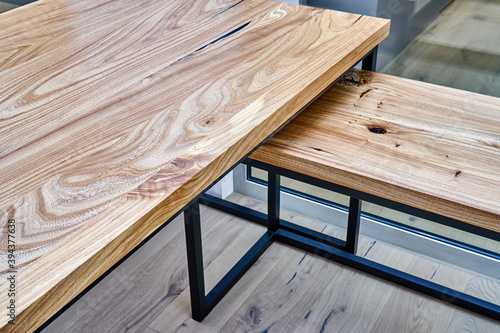 Live edge elm desk with metal base in a modern home office. Fragment of the desk