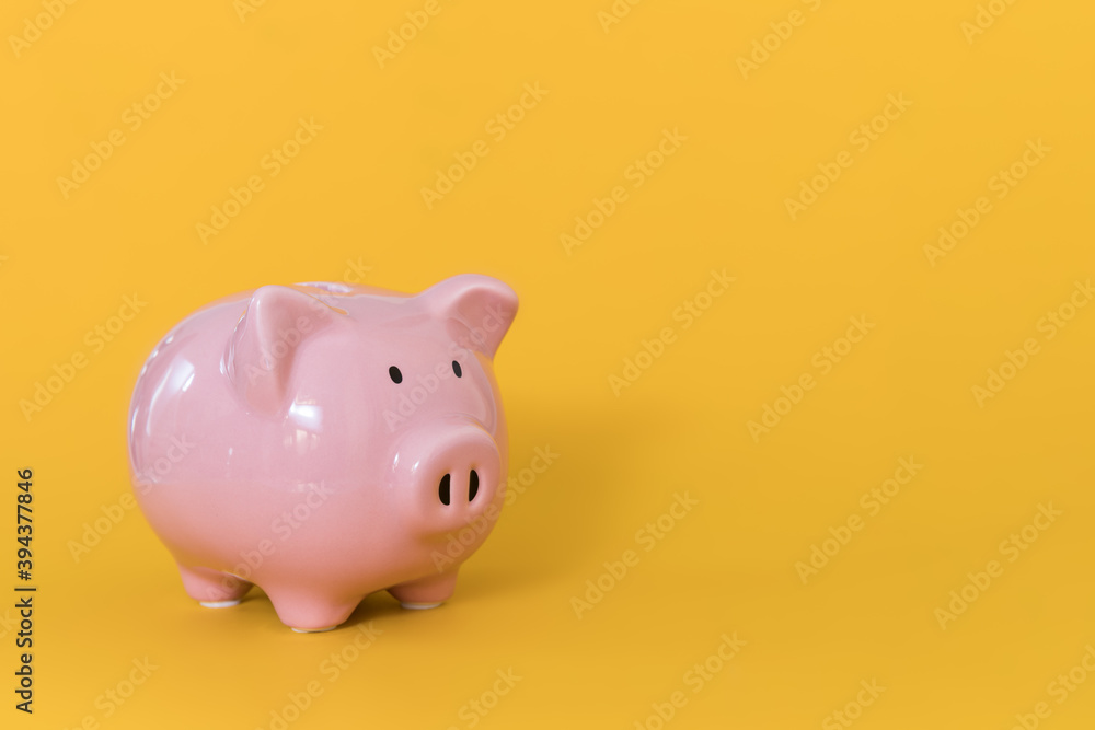 Piggy bank on yellow background for economy, saving money wealth and financial concept Piggy bank on yellow background for economy, saving money wealth and financial concept