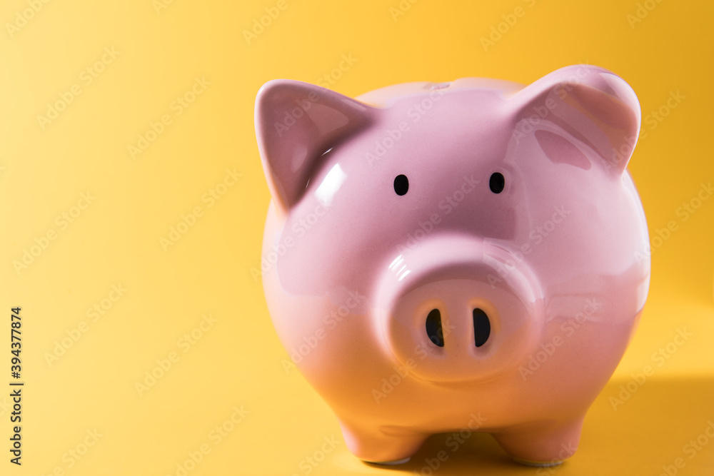 Piggy bank on yellow background for economy, saving money wealth and financial concept Piggy bank on yellow background for economy, saving money wealth and financial concept
