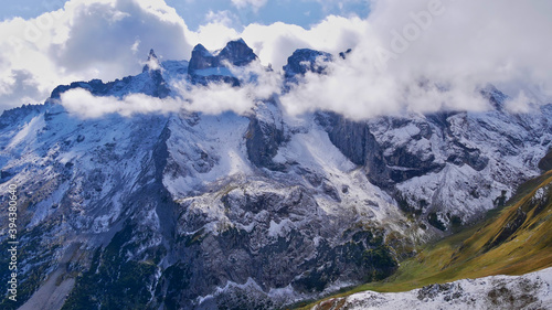 Beautiful panorama view of snow-covered alpine mountains with the popular three towers  2 830 m  German  Drei T  rme  in the R  tikon mountains in Montafon  Austria surrounded by clouds.